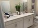 Bathroom featuring a double vanity, framed mirror, toilet, and decor at 1077 Quaker Ridge Ln, Davenport, FL 33896