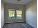 Cozy bedroom with a ceiling fan, carpet, and large windows showcasing green outdoor views at 1077 Quaker Ridge Ln, Davenport, FL 33896