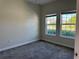Bright bedroom with neutral walls, plush carpet, and natural light from two windows at 1077 Quaker Ridge Ln, Davenport, FL 33896