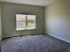 Bright bedroom with carpet, a single window, and light-colored walls at 1077 Quaker Ridge Ln, Davenport, FL 33896