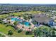 Aerial view of a beautiful community pool area with palm trees, lounge chairs, and resort-style amenities at 1077 Quaker Ridge Ln, Davenport, FL 33896