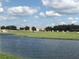 Scenic golf course with lush greenery, a serene lake, and charming residential homes in the background, offering relaxation at 1077 Quaker Ridge Ln, Davenport, FL 33896