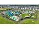 Aerial view of a community water park featuring slides, pools, and lush landscaping at 1077 Quaker Ridge Ln, Davenport, FL 33896