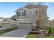 Charming two-story home showcasing a manicured lawn and a neutral color scheme with stone accents at 199 Bull Frog Ln, Umatilla, FL 32784