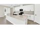 Bright, modern kitchen with a large island, white cabinets, and stainless steel appliances at 199 Bull Frog Ln, Umatilla, FL 32784