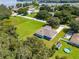 An aerial view reveals the home, long driveway, and expansive yard with a pool and lake views at 319 Water Shore Dr, Leesburg, FL 34748
