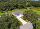 Aerial view of a single-Gathering home with a long driveway and an expansive lawn surrounded by trees at 319 Water Shore Dr, Leesburg, FL 34748