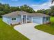 Beautiful single-story home with blue paint, stone accents, well-manicured lawn and a long curved driveway at 319 Water Shore Dr, Leesburg, FL 34748