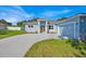 Charming single-story home with a well-manicured lawn and a light blue exterior and stone accents at 319 Water Shore Dr, Leesburg, FL 34748