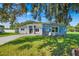 Charming single-story home with a well-manicured lawn and a light blue exterior and stone accents at 319 Water Shore Dr, Leesburg, FL 34748