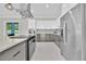 Modern kitchen featuring stainless steel appliances, gray cabinets, and a central island with cooktop at 319 Water Shore Dr, Leesburg, FL 34748