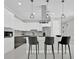 Modern kitchen with white cabinets, stainless steel appliances, and center island with pendant lighting at 319 Water Shore Dr, Leesburg, FL 34748