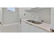 Modern laundry room featuring bright white cabinets, counter tops and flooring at 319 Water Shore Dr, Leesburg, FL 34748