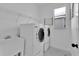 Clean laundry room with modern washer, dryer, sink, window, and shelving at 1740 N Hampton Dr, Davenport, FL 33897