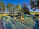 View of playground with slide, climbing bars, and tennis court in the background at 1740 N Hampton Dr, Davenport, FL 33897