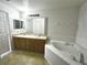 Large bathroom with double sinks, a soaking tub, and neutral tile flooring at 1928 Drum Dr, Kissimmee, FL 34759