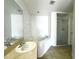 Bright bathroom features a soaking tub, glass-enclosed shower, and spacious vanity with a large mirror at 1928 Drum Dr, Kissimmee, FL 34759