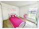 Cozy bedroom with a pink bed, bright decor, and natural light at 1928 Drum Dr, Kissimmee, FL 34759