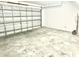 Spacious garage with a metal door and concrete floor provides ample room for parking and storage at 1928 Drum Dr, Kissimmee, FL 34759