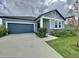 Beautiful single-story home featuring a two-car garage, stone accents, and lush green landscaping at 2236 Derwent Dr, Davenport, FL 33896