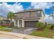 Two-story house with gray exterior, palm trees, and a paved driveway at 331 Ballo Dr, Kissimmee, FL 34746