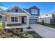 Two-story house with gray siding, stone accents, and a two-car garage at 4200 Sawtooth Ct, Tavares, FL 32778