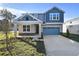 Two-story house with gray siding, stone accents, and a two-car garage at 4200 Sawtooth Ct, Tavares, FL 32778