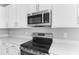 Stainless steel appliances and white cabinets in a modern kitchen at 4200 Sawtooth Ct, Tavares, FL 32778