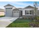 Beautifully landscaped home featuring a stone facade and a three-car garage at 4224 Sawtooth Ct, Tavares, FL 32778