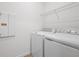 Laundry room with full-size washer and dryer, complete with overhead shelving at 4224 Sawtooth Ct, Tavares, FL 32778