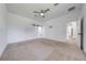 Bedroom features neutral carpet, ceiling fan, and sliding door to bathroom at 2909 Annalee Rd, Saint Cloud, FL 34771
