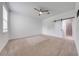 Bedroom features neutral carpet, ceiling fan, and sliding door to bathroom at 2909 Annalee Rd, Saint Cloud, FL 34771