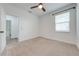 Bright bedroom features neutral carpet, a ceiling fan, and a window with natural light at 2909 Annalee Rd, Saint Cloud, FL 34771