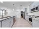 Kitchen featuring stainless steel appliances, granite countertops, island sink, and adjacent laundry area at 2909 Annalee Rd, Saint Cloud, FL 34771