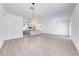 Spacious living room featuring light gray flooring, pendant lighting, and an open concept to the kitchen at 2909 Annalee Rd, Saint Cloud, FL 34771