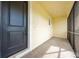 Screened in front porch with concrete flooring, black door, and beige siding at 2909 Annalee Rd, Saint Cloud, FL 34771