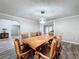 Dining room with a large wooden table, eight chairs, and a modern light fixture at 32122 Hickory Ln, Sorrento, FL 32776