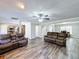 Living room with brown leather couches, a fireplace, and a large TV at 32122 Hickory Ln, Sorrento, FL 32776