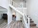 Elegant staircase with white railing and wood floors at 32122 Hickory Ln, Sorrento, FL 32776