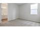Bright bedroom showcasing neutral walls, soft carpeting, and an attached bathroom at 192 Flag Lilly Ln, Umatilla, FL 32784
