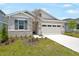 Beautiful single-Gathering home featuring stone accents, neutral paint colors, well-maintained lawn, and an attached two-car garage at 196 Flag Lilly Ln, Umatilla, FL 32784