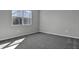 Neutral bedroom with a large window providing natural light and soft carpet floors at 203 Bull Frog Ln, Umatilla, FL 32784