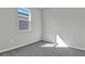 This bedroom has gray carpeting and natural light from the window at 203 Bull Frog Ln, Umatilla, FL 32784