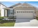 Charming single-story home with a two-car garage, stone accents, and fresh landscaping at 203 Bull Frog Ln, Umatilla, FL 32784