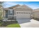 Charming single-story home with a two-car garage, stone accents, and fresh landscaping at 203 Bull Frog Ln, Umatilla, FL 32784