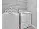 Laundry room featuring a white washer and dryer, with a wire shelf above at 203 Bull Frog Ln, Umatilla, FL 32784