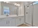 Bright bathroom featuring double vanity, white cabinets, and a glass-enclosed shower at 207 Bull Frog Ln, Umatilla, FL 32784