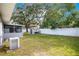 This backyard boasts lush greenery, a storage shed, white fencing and access to a screened-in patio at 3000 Cashmere Dr, Orlando, FL 32827