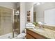 Well-lit bathroom with a granite countertop vanity and glass enclosed shower at 4891 Clock Tower Dr, Kissimmee, FL 34746