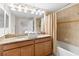 Bright bathroom featuring a double vanity with granite countertops and a shower-tub combo at 4891 Clock Tower Dr, Kissimmee, FL 34746